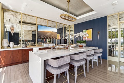 a kitchen with a marble counter top and a long bar with chairs