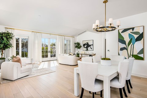 A white dining room with a large table and chairs.