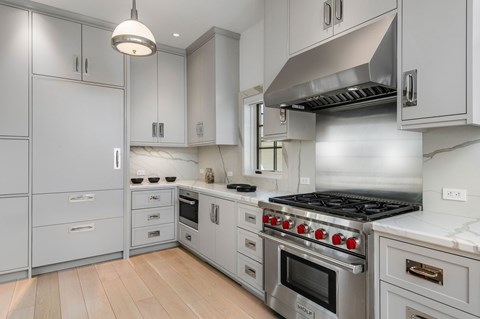 A modern kitchen with a stainless steel stove and white cabinets.