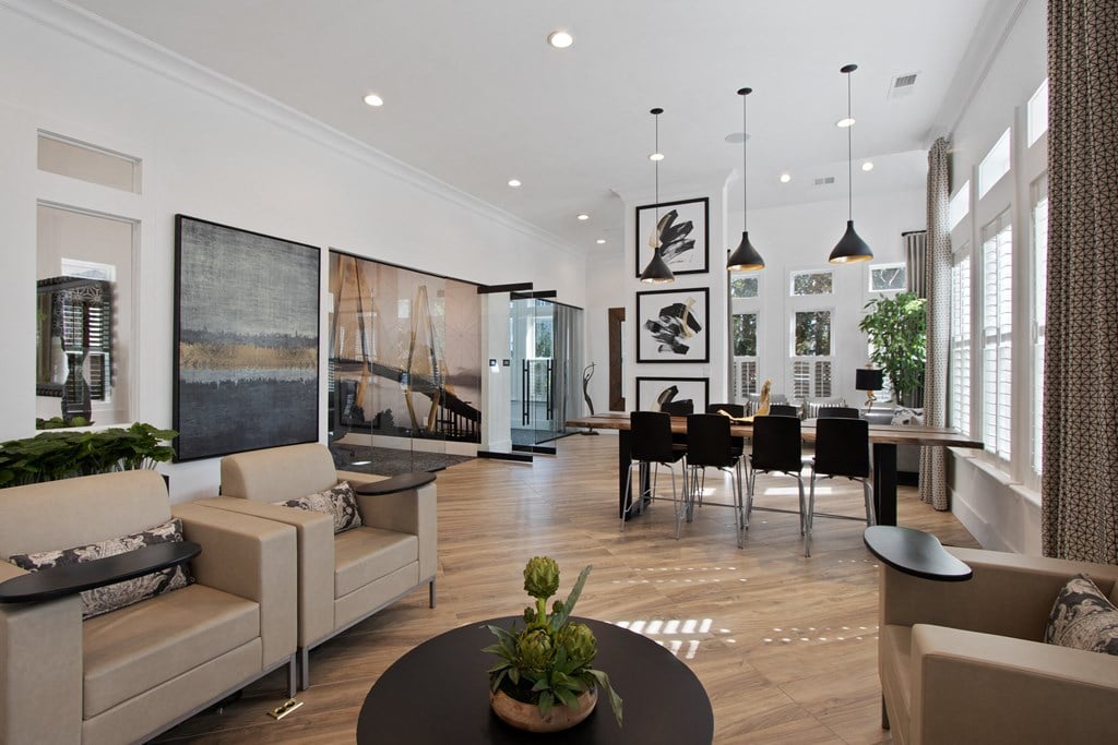 a living room and dining room with white walls and wood floors