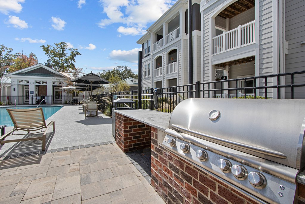 a barbecue grill on a brick wall next to a pool