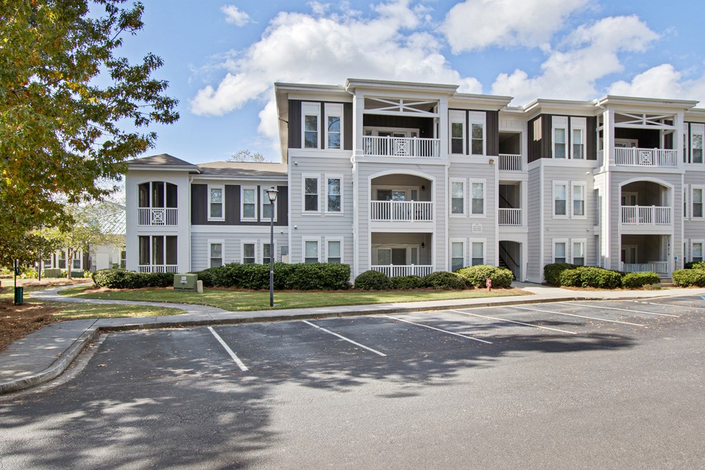 an apartment building with a parking lot in front of it