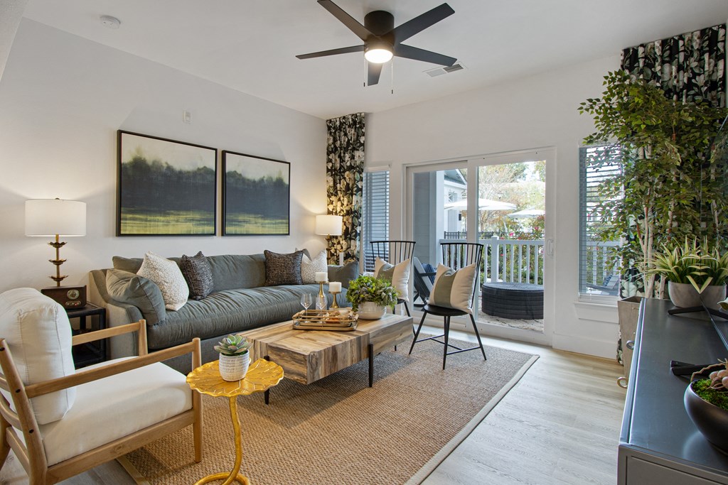 a living room with a couch and a coffee table and a ceiling fan