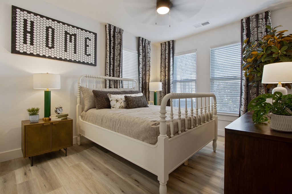 a bedroom with a bed and a dresser and windows