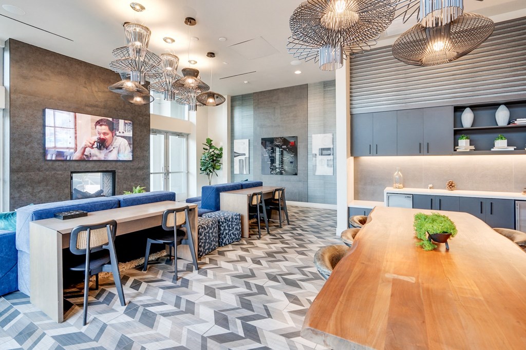 A modern office space with a long wooden table and blue chairs.
