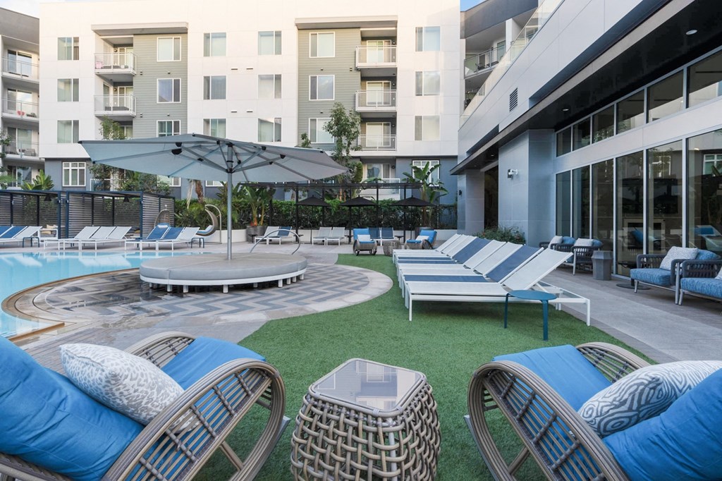 A round pool surrounded by lounge chairs and umbrellas.