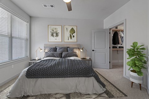 A bedroom with a large bed and a ceiling fan.
