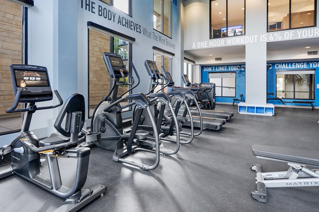 A gym with a row of exercise bikes and a sign that says