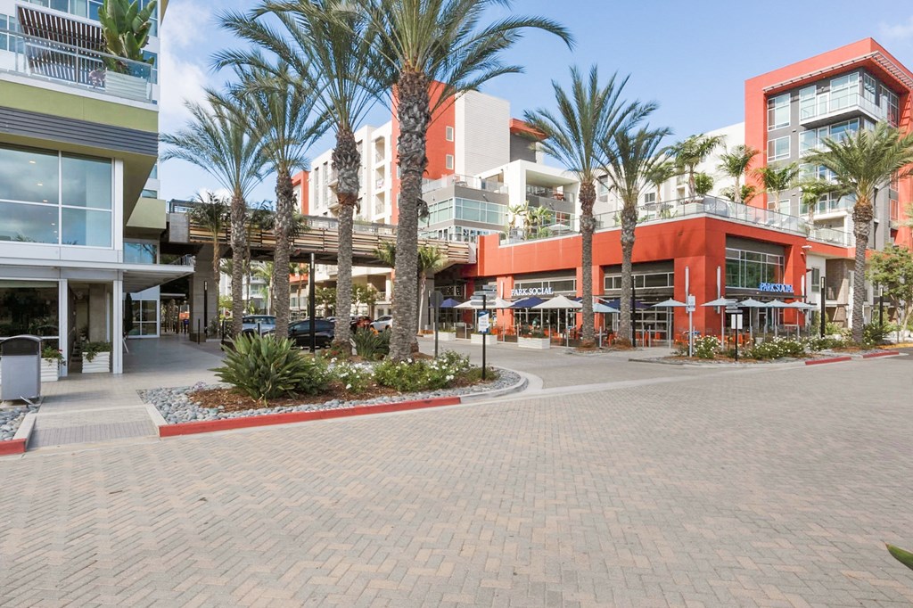 A shopping center with palm trees in front.