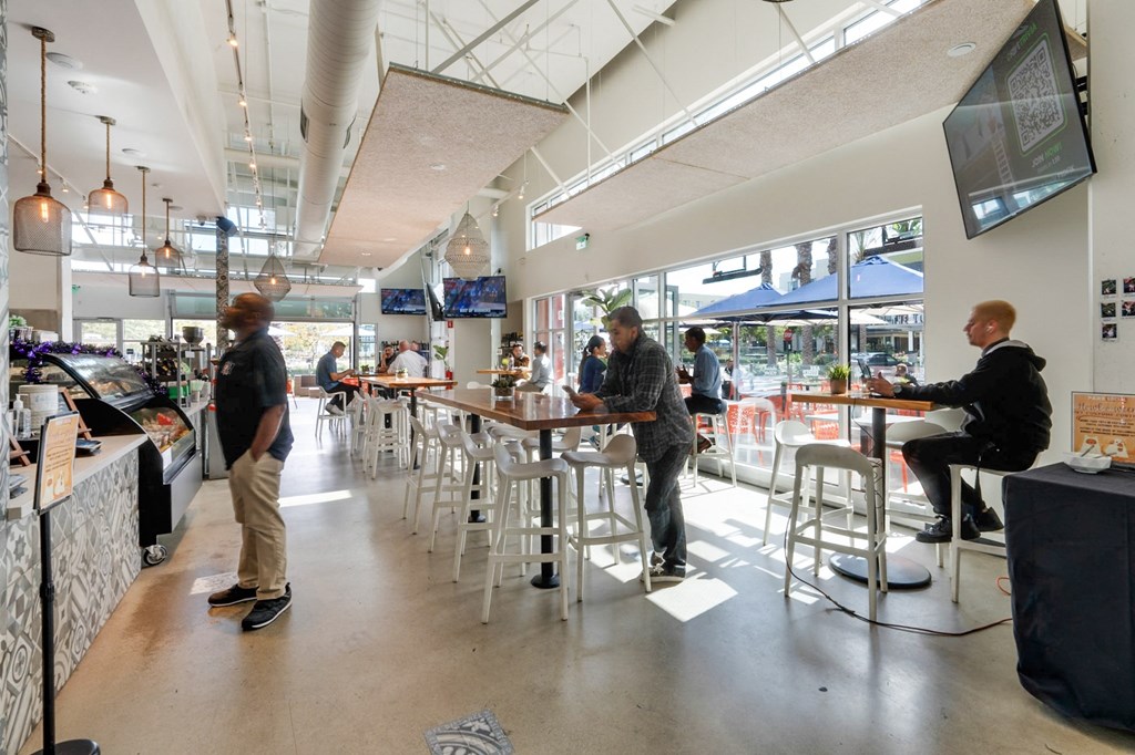 A man is sitting at a table in a brightly lit restaurant.