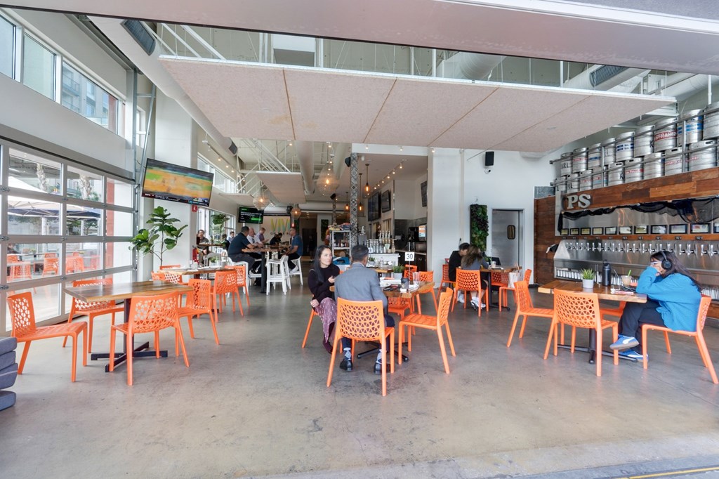 A group of people are sitting at tables in a brightly lit restaurant.