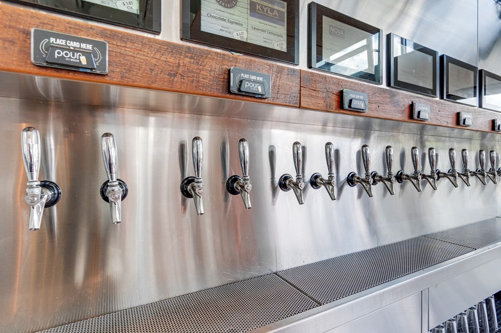 A stainless steel beer tap line with a wooden board above it.