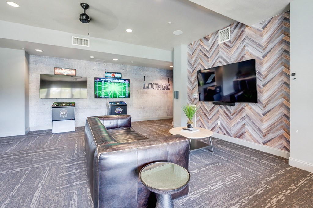 A room with a couch, a chair, and a television.