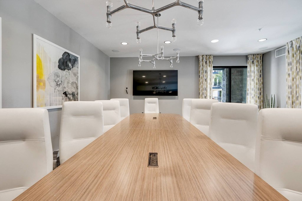 A conference room with a long table and chairs.