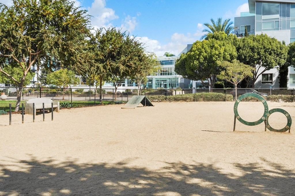 A playground with a sandy area, a slide, and a green ring.