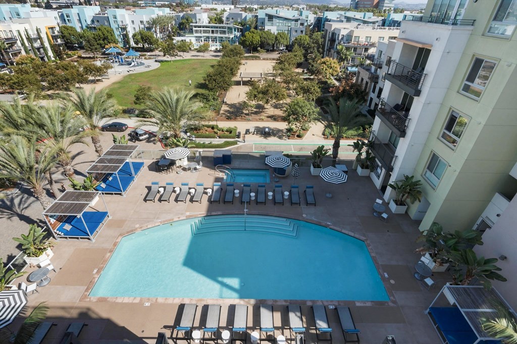 A large swimming pool surrounded by sun loungers and umbrellas.