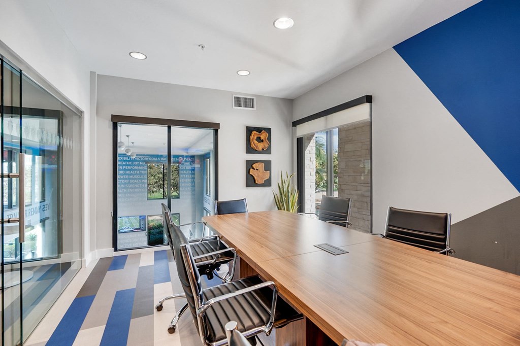 A conference room with a long table and chairs.