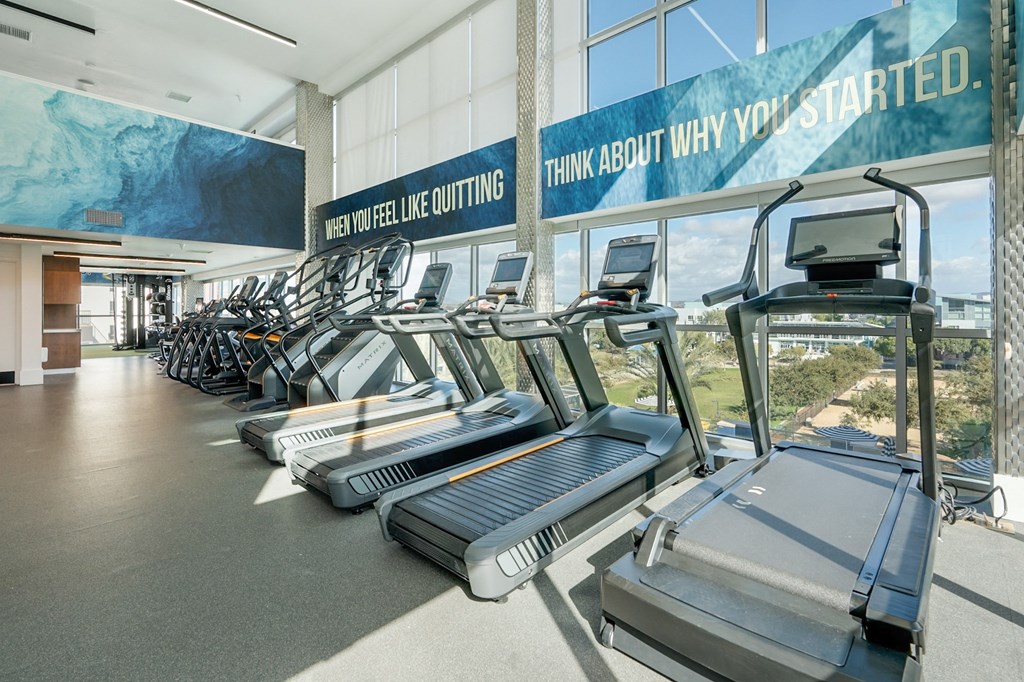 A gym with treadmills and a sign that says "Think about why you started.".