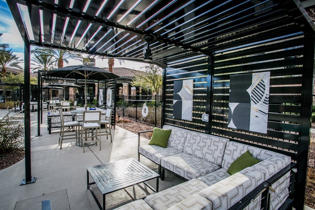 a patio with couches and tables and a pergola