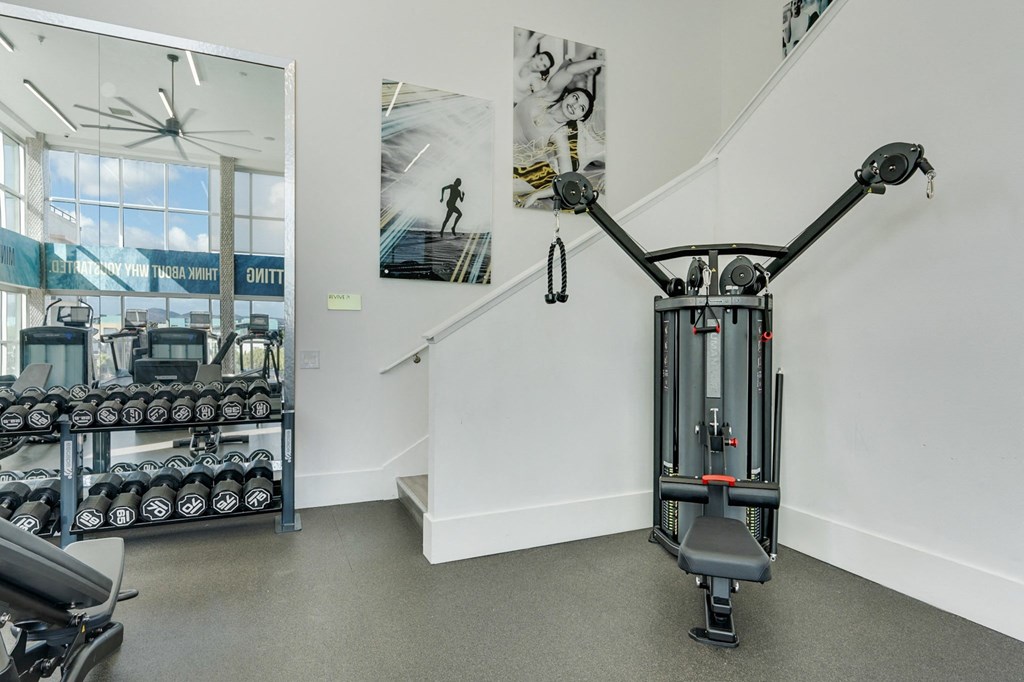 A gym with a weightlifting machine in the foreground.