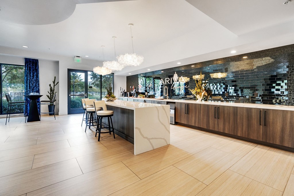 A modern kitchen with a bar area and a dining table.