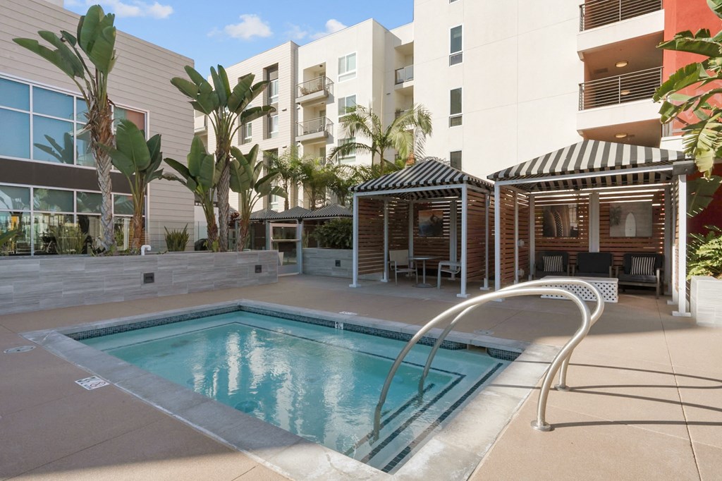 A pool with a slide and a building behind it.