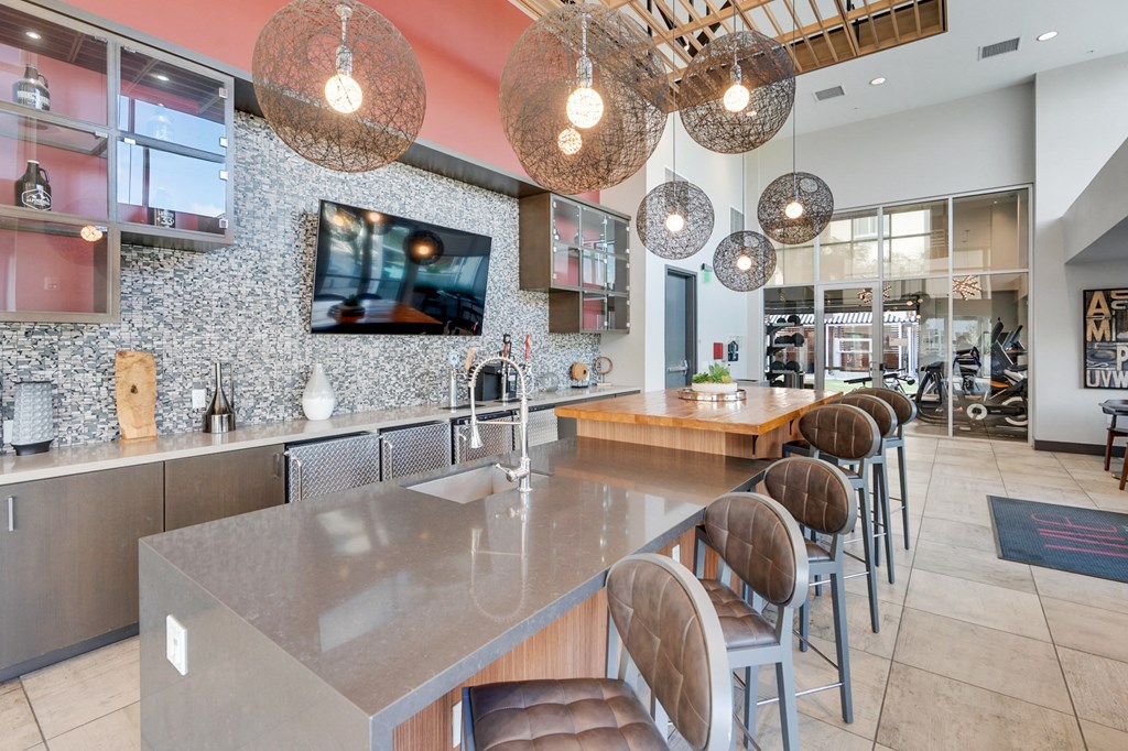 A modern kitchen with a long island and chairs.