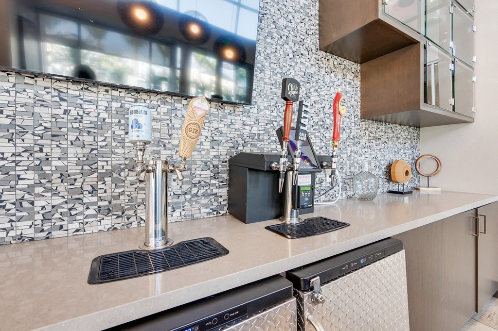 A kitchen with a black and white tiled backsplash and a black dishwasher.