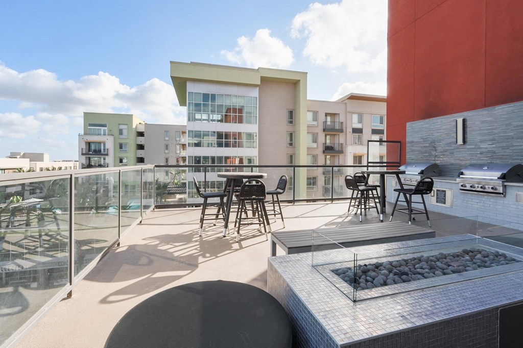 A modern outdoor kitchen area with a grill and seating area.