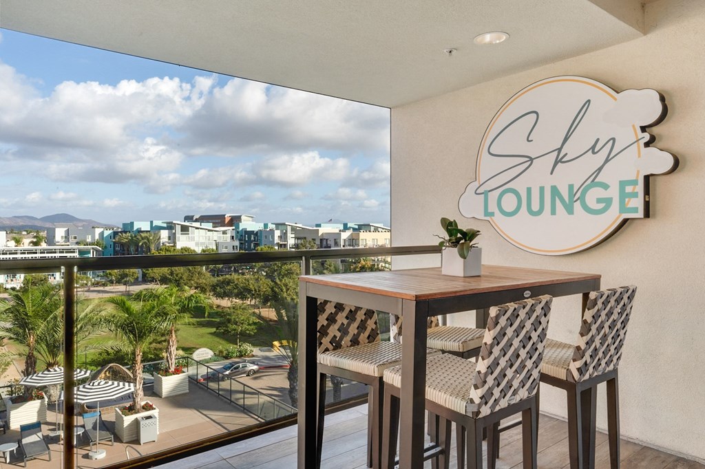 A balcony with a table and chairs and a sign that says Sky Lounge.