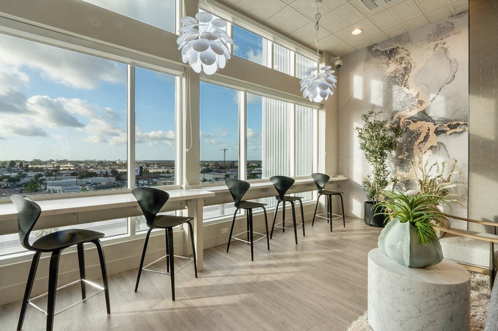 A room with a view of the city through large windows.