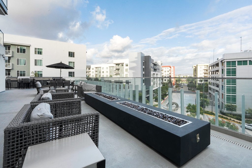 A black and white outdoor seating area with a long table and chairs.
