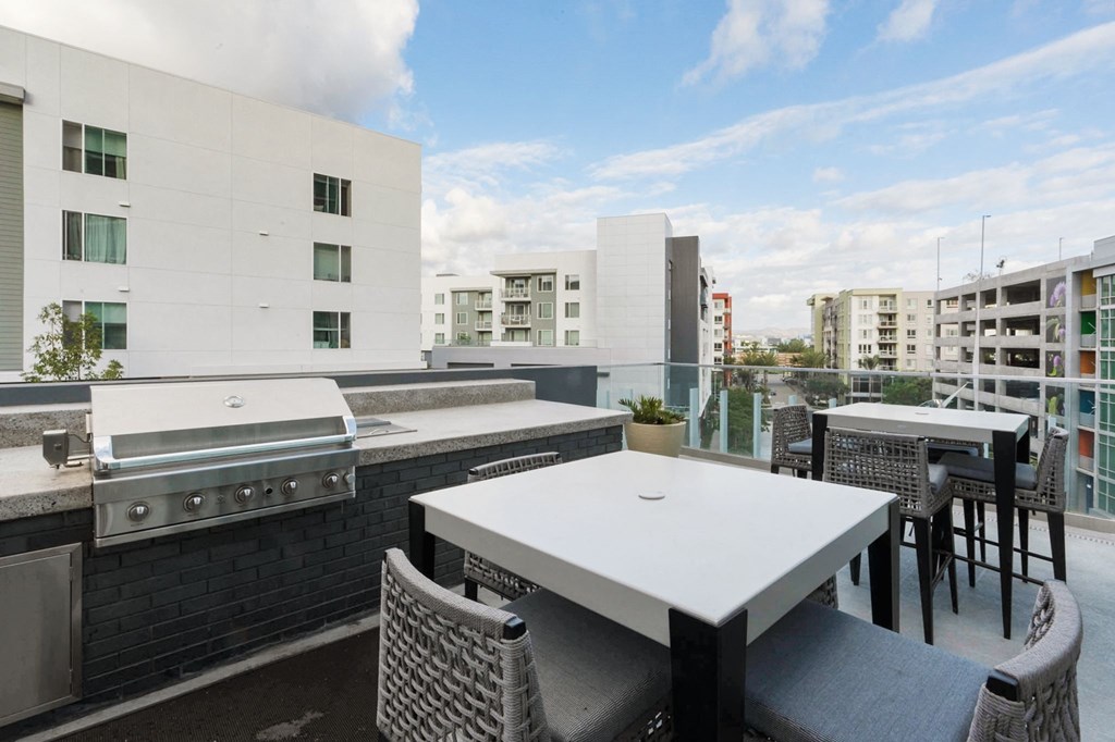 A patio with a table and chairs overlooking a cityscape.