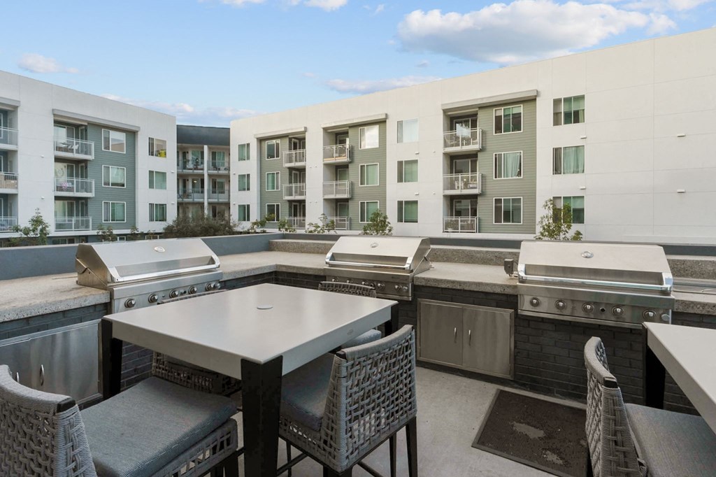 A patio with a table and chairs overlooking apartment buildings.