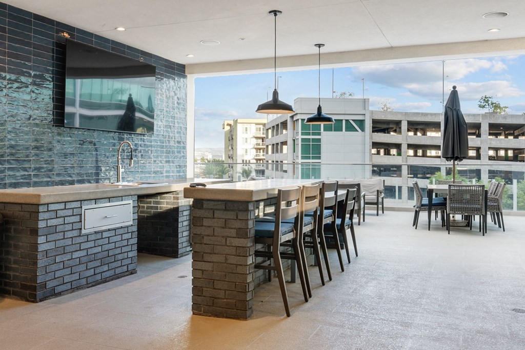 A modern bar area with a television and a view of the city.
