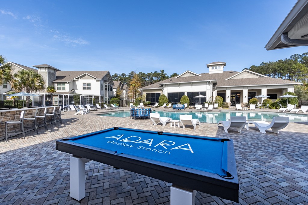 a pool with a table in front of a house