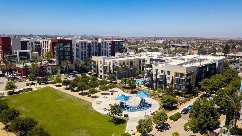 A large building complex with a pool in the middle of a grassy area.