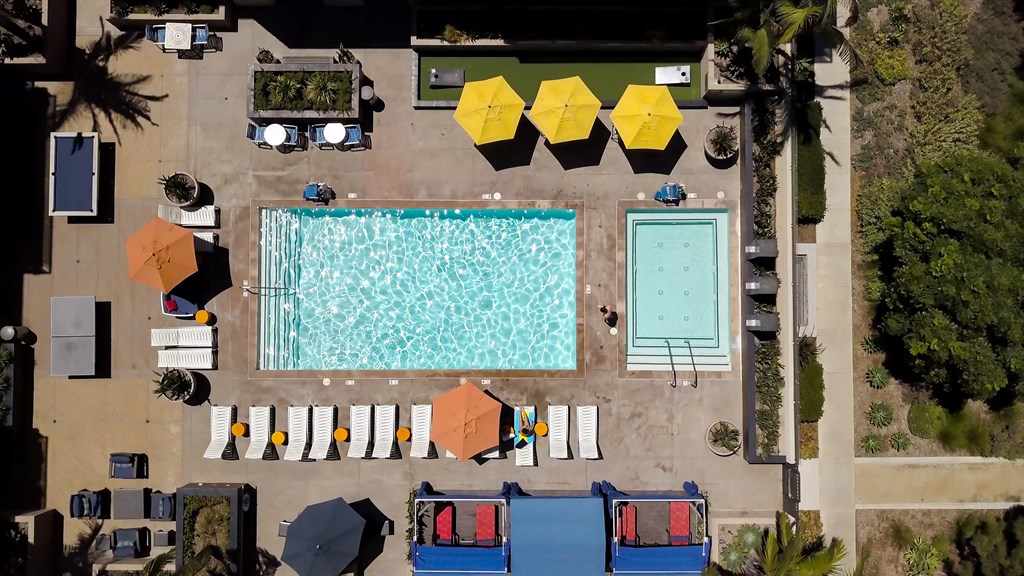 arial view of a swimming pool with lounge chairs and umbrellas