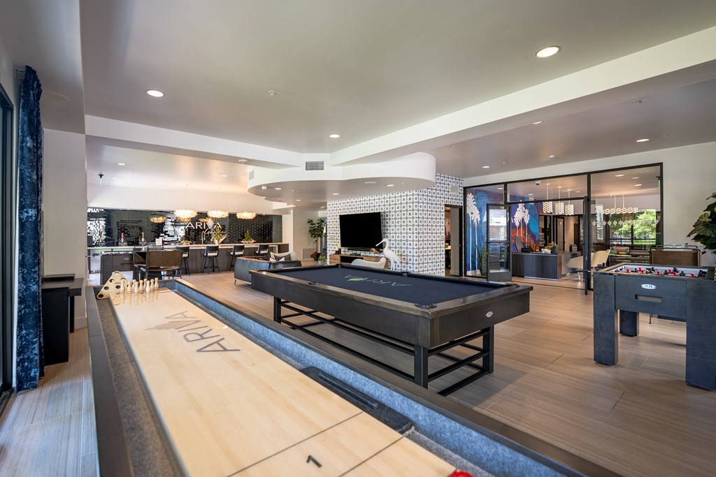 a games room with a shuffleboard table and foosball table