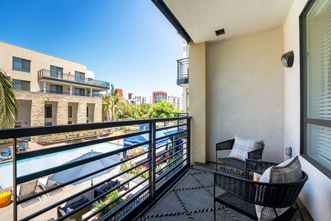 a balcony with a seating area and a view of the water