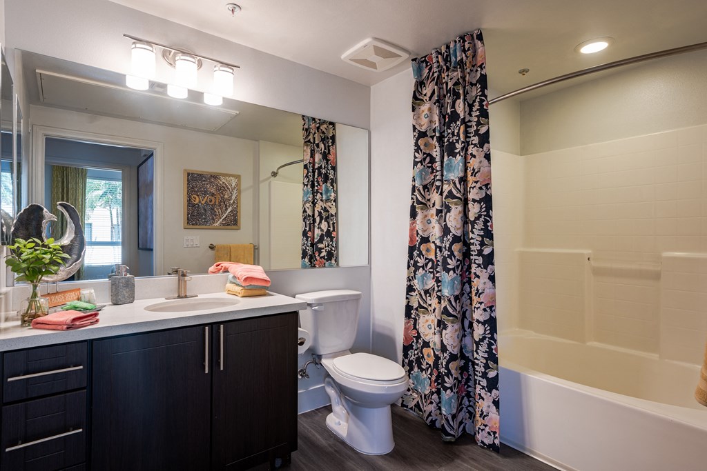 a bathroom with a white toilet next to a bathtub with a shower curtain