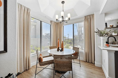 A dining room with a round table and chairs.