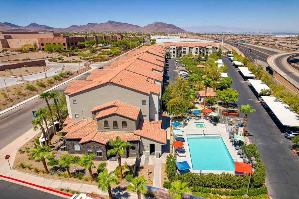 an aerial view of a building with a pool and parking lot