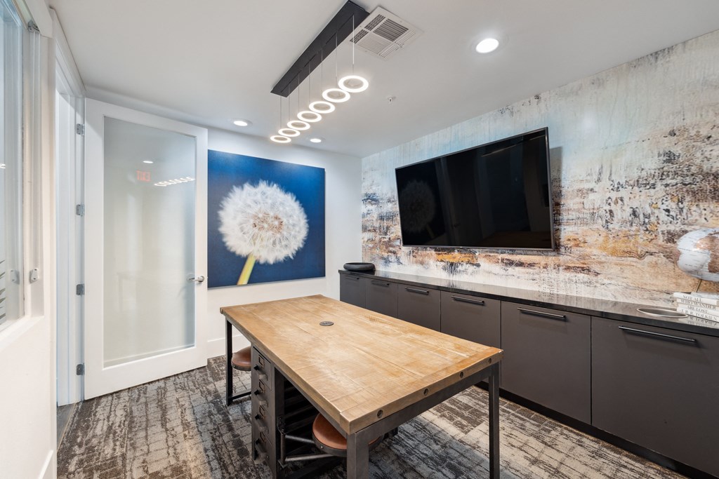 a dining room with a table and a tv on the wall