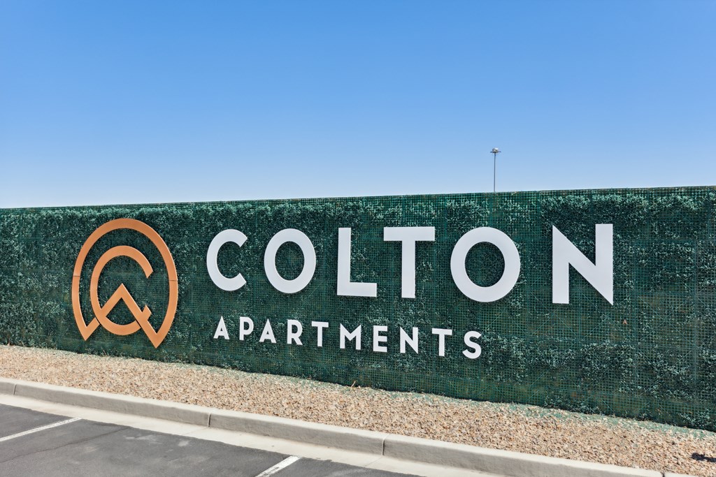a green wall with the colton apartments logo on it