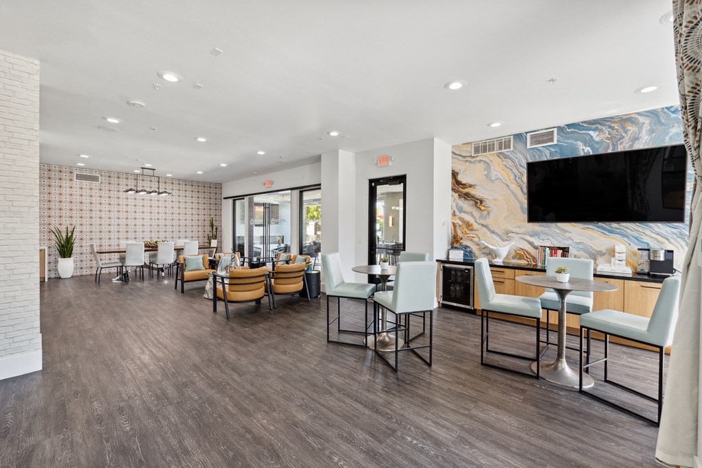a dining room with tables and chairs and a tv on the wall