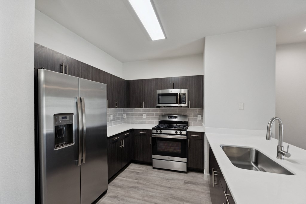 a kitchen with stainless steel appliances and white counter tops