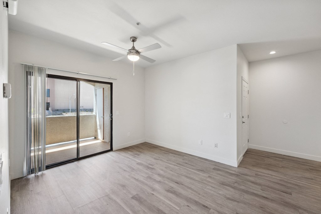 an empty living room with a sliding glass door to a patio