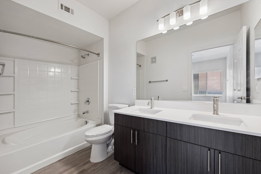 a bathroom with a large mirror and a sink and a toilet