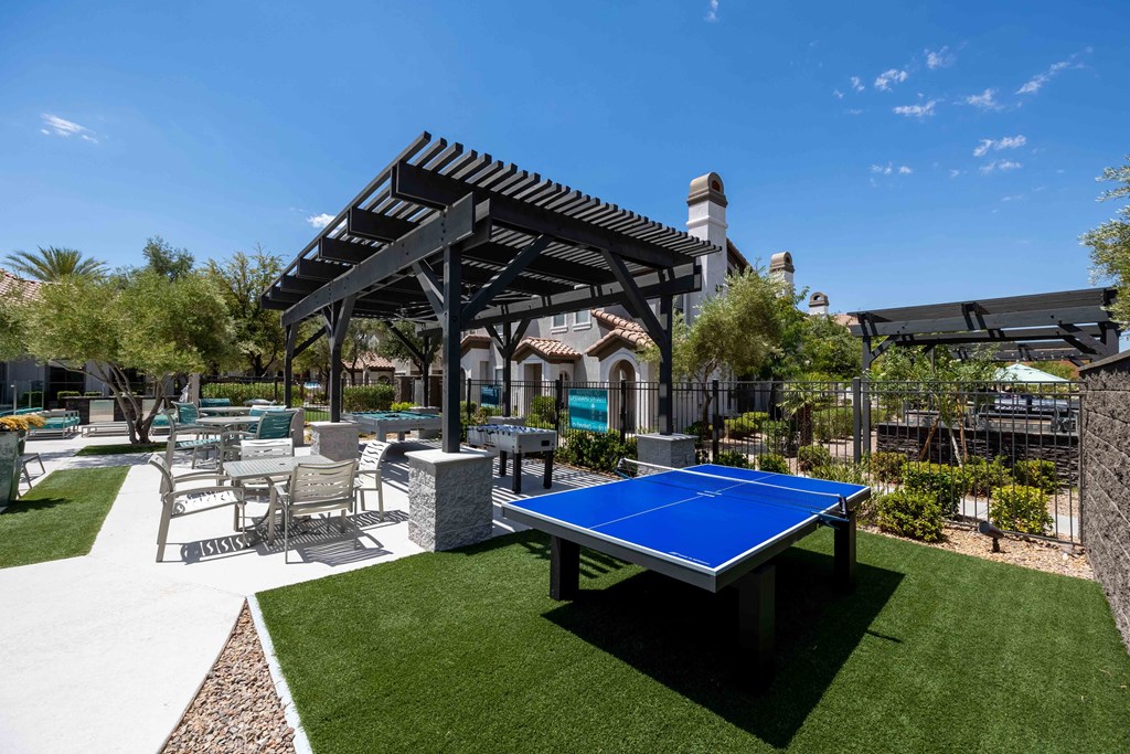 clubhouse with ping pong table and patio with chairs and a pergola